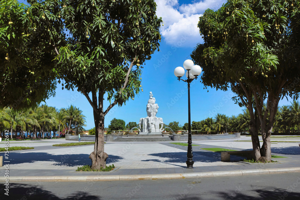 Fototapeta premium Nha trang, Long Son Pagoda (Vietnam) Fountain with statues of elephants and lions in the park with tropical flowers and palm trees under sunlight