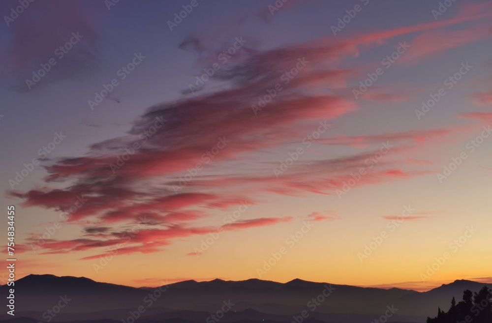 Nuvole rosse nel cielo sopra le montagne nel tramonto dorato