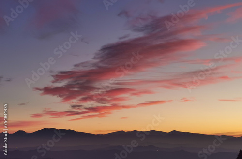 Nuvole rosse nel cielo sopra le montagne nel tramonto dorato © GjGj