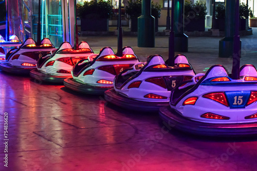 Coches de choque en fila en el parque de atracciones por la noche.