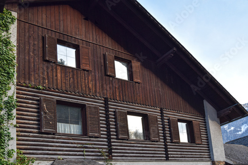 Casa de madera con las compuertas abiertas de las ventanas