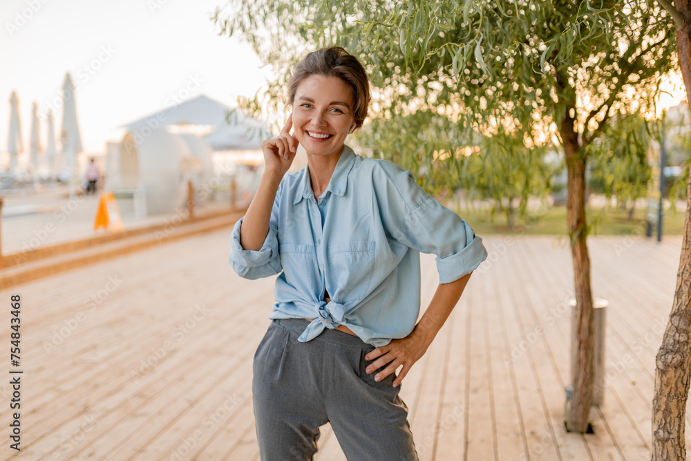 Fototapeta premium young pretty woman in casual summer style in modern park street
