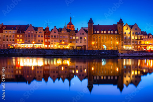 Gdansk, Poland - April 3, 2022: Scenery of the old town in Gdansk reflected in the Motlawa river at dusk, Poland.