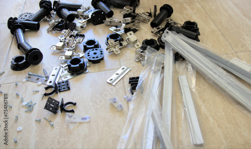 Scattered furniture hardware for assembling new furniture to furnish a room.