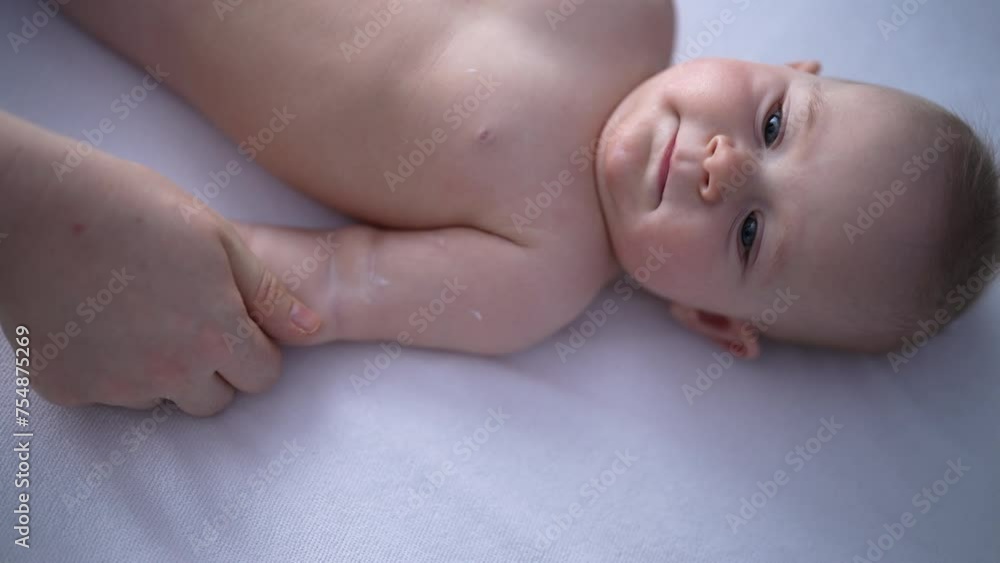 Top view of unrecognizable loving mother doing massage arms and shoulder of cute newborn. Pretty infant baby lying on cozy bed at back. Adorable baby boy relaxing time doing massage mom at home. Top view of unrecognizable loving mother doing massage arms and shoulder of cute newborn. Pretty infant baby lying on cozy bed at back. Adorable baby boy relaxing time doing massage mom at home.