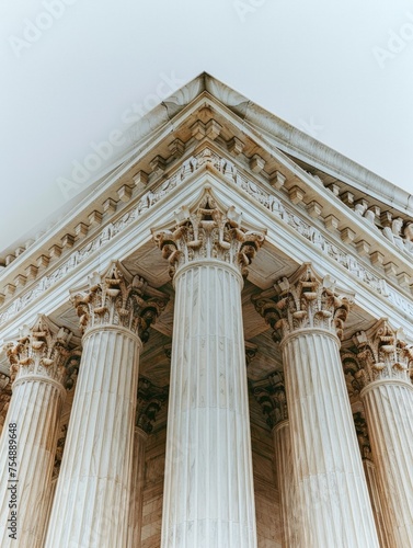 Low Angle View of US Supreme Court Justice Building Exterior Marble Columns, White Sky Background
