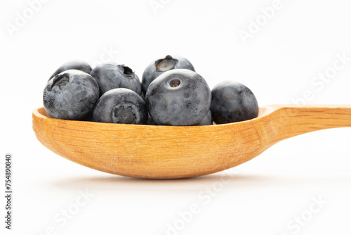 Wild blueberry in a wooden spoon isolated on a white background.