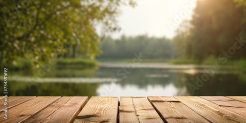Wooden deck overlooking a serene lake surrounded by lush greenery and bathed in warm sunlight.