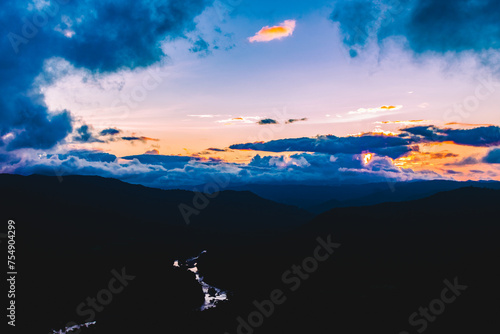 Sunset in the mountains with a river flowing through the valley at Jenukallugudda, Karnataka, India photo