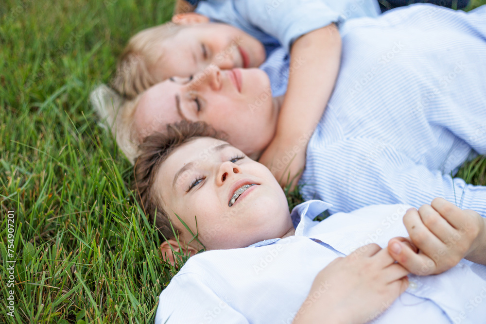 A beautiful family is lying on the green grass together. A beautiful family is lying on the green grass together.