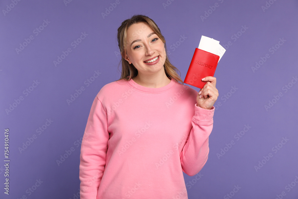 Happy young woman with passport and ticket on purple background Happy young woman with passport and ticket on purple background