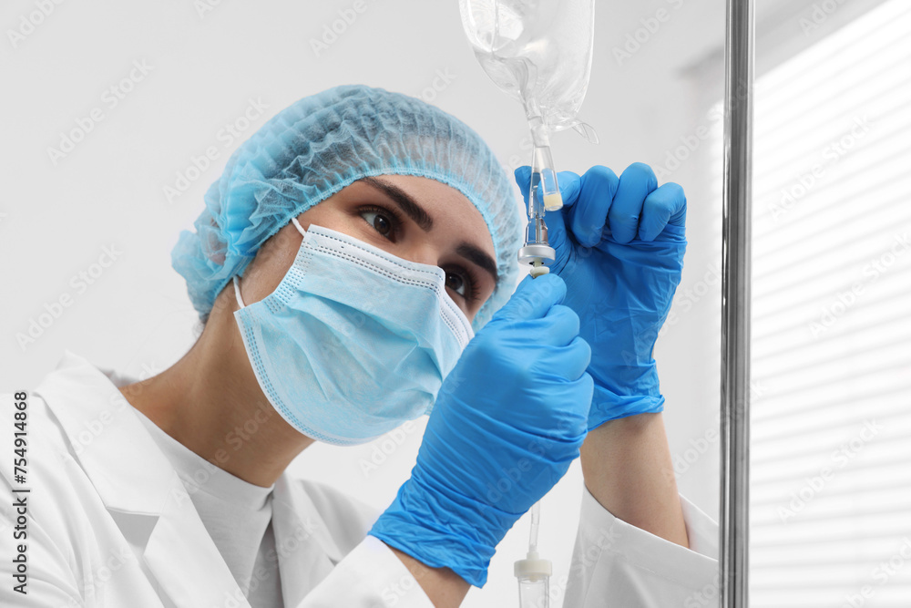 Naklejka premium Nurse setting up IV drip in hospital