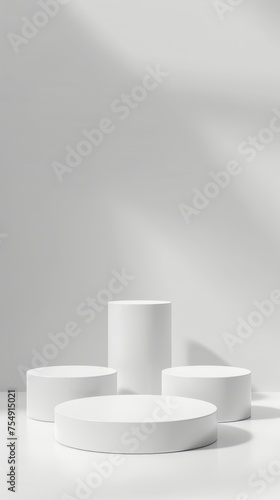 White cylindrical podiums in a minimalist setting with elegant shadow play, ideal for product display and contemporary design.