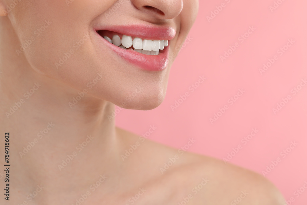 Obraz premium Young woman with beautiful smile on pink background, closeup