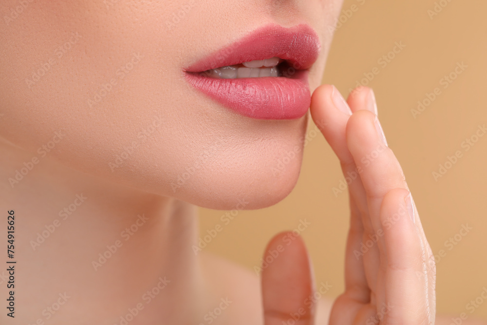 Obraz premium Young woman with beautiful full lips on beige background, closeup