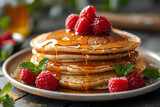 A tasty stack of golden pancakes drizzled with syrup and topped with ripe raspberries and a hint of mint, served on a rustic plate, perfect for a hearty breakfast