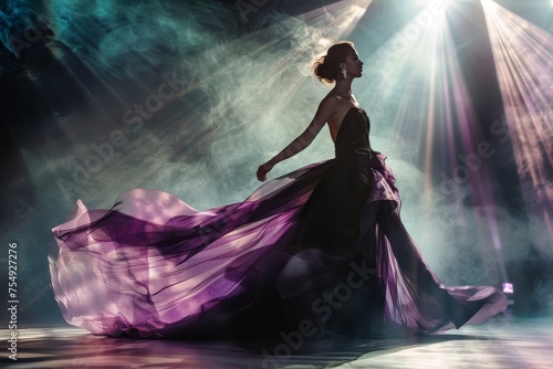 Elegant dancer in a flowing purple dress amidst dramatic lighting