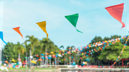 Summer fair flag bunting colorful background hanging on blue sky for fun fiesta party event, summer holiday farm feast celebration, carnival festival event, park or street festa design decoration