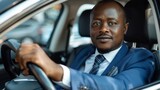 Successful African businessman in suit and tie sitting at the steering wheel of his car going to company.