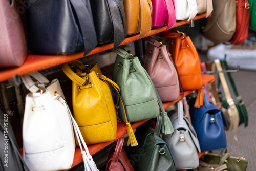 Close up of different leather bags on market. Modern colorful bags for sale. Womanly accessories