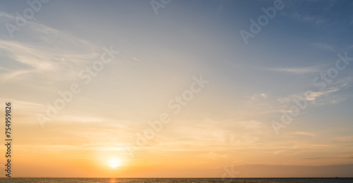 Sunset sky clouds over sea in the evening with orange sunlight, Horizon sea sky landscape background and sun down in Golden Hour summer season 
