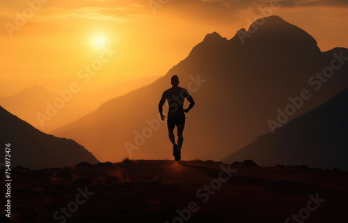 A man is running on a mountain trail at sunset