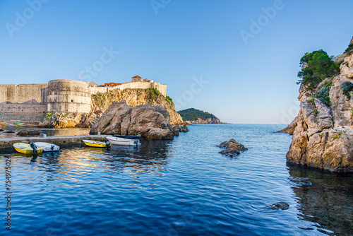 Dubrovnik medieval walls at the West Harbour beach on the shores of the Adriatic Sea; Mediteranean Sea riviera in Dubrovnik, Croatia