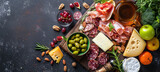 An assortment of cheeses, meats, fresh fruits, nuts and snacks is beautifully laid out on a wooden board.