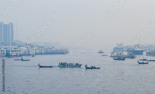 Sadarghat river view landscape, Transporting local people by small boats across the river, Commuter ferryboat in the monsoon, Boat ride in the Buriganga river.