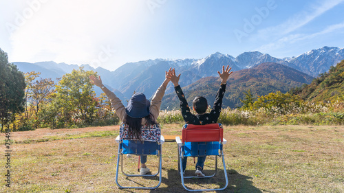 Mountain traveler couple relaxing, take it easy enjoying tourist adventure mountaintop travel freedom, mountaineering height of outdoor hill top trip with panoramic view of nature peak and sky horizon © Chinnapong