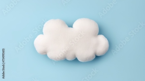 Knitted toy white cloud on a blue background. Children's clothes and accessories. View from above. © Cherkasova Alie