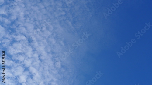 Blue sky full screen background with half mackerel sky and half clear blue sky