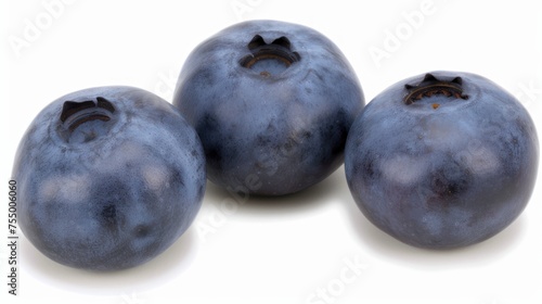 three blueberries sitting next to each other on top of a white surface and one has a bite taken out of it.