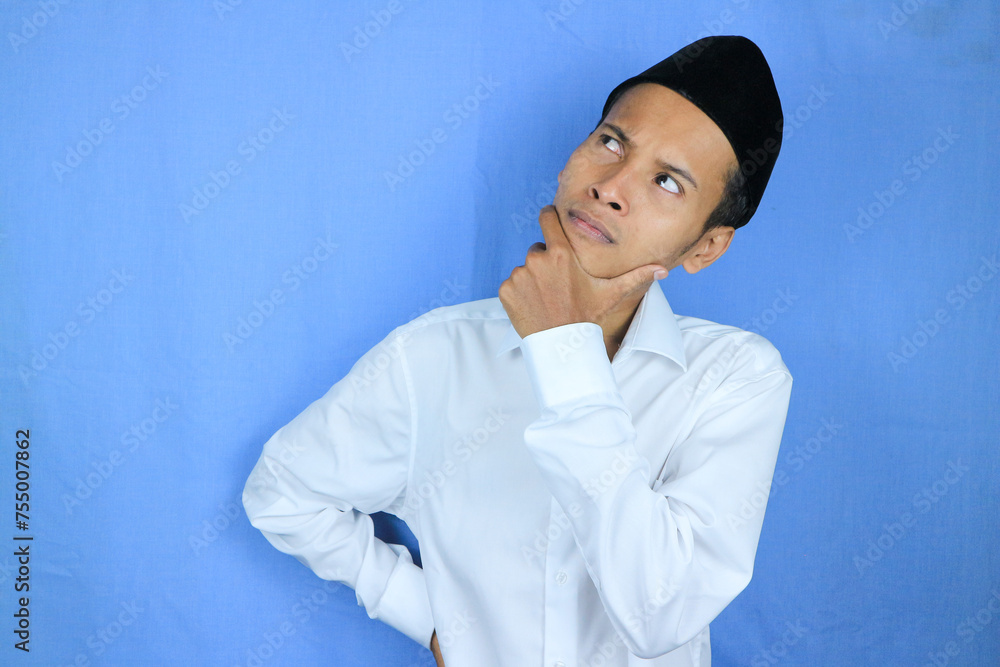 Confuse expression of asian muslim man doing thinking gesture, looking for idea on white background Confuse expression of asian muslim man doing thinking gesture, looking for idea on white background