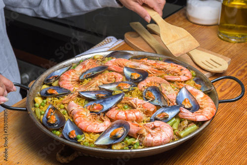 A traditional Spanish paella with shrimp and mussels in a rustic kitchen setup, typical Spanish cuisine, Majorca, Balearic Islands, Spain