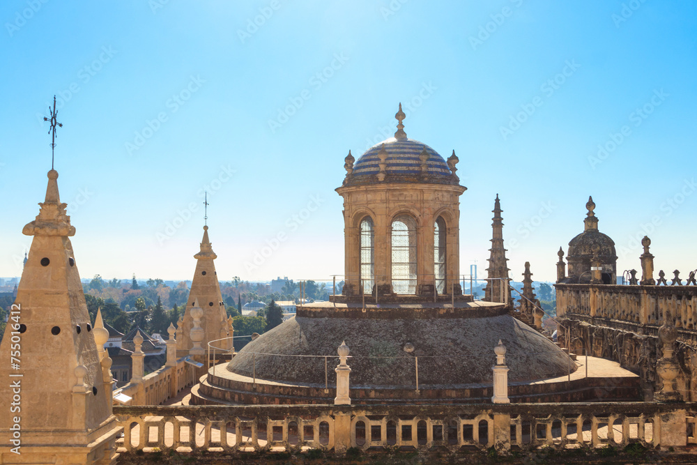View from the Giralda Tower out over the roof and spires of the Seville cathedral with the city in view in Seville, Spain