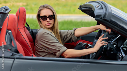 Entrepreneurial woman exuding elegance and success while seated in her purchased convertible