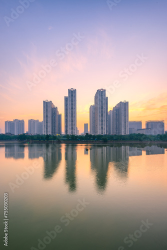 Buildings with reflections on lake at sunset at An Binh City, Hanoi. © VietDung