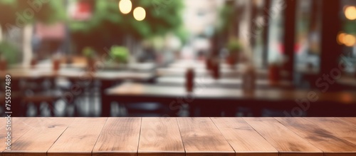 An empty wooden table is set against a blurred background, which appears to be a coffee shop. The table is ideal for displaying or showcasing various products in a mock-up setting.