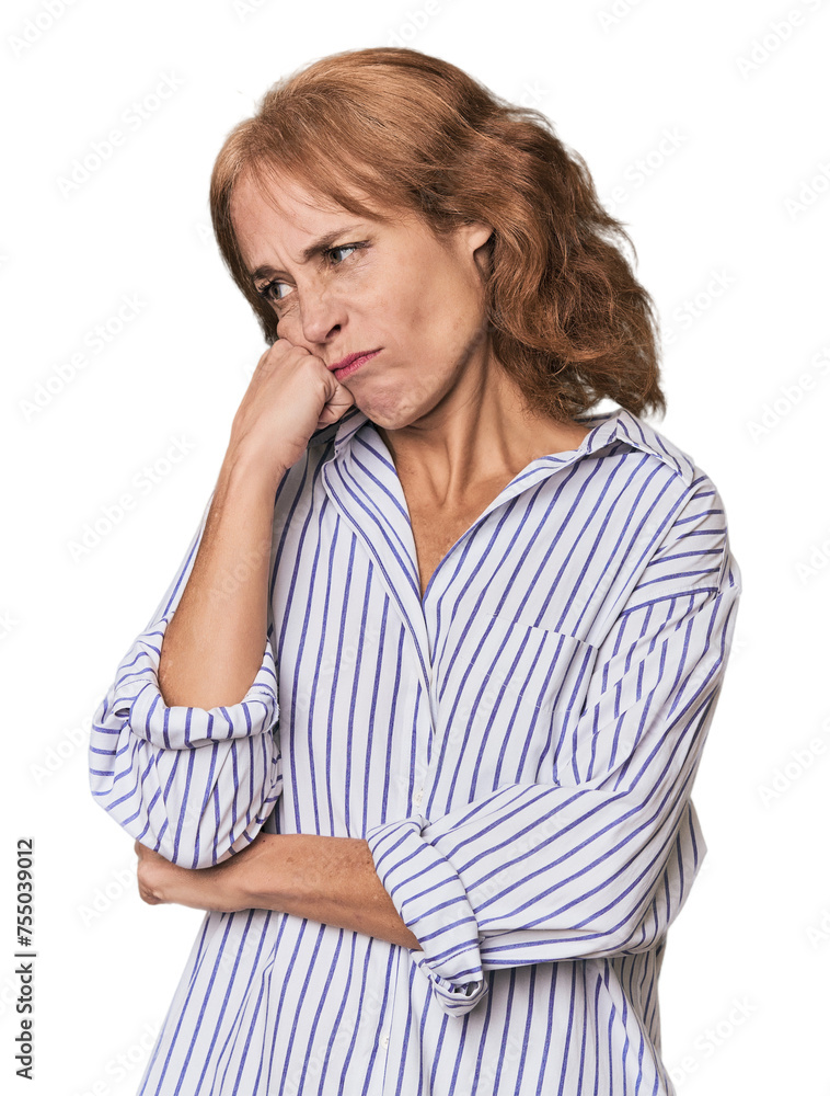 Redhead mid-aged Caucasian woman in studio who feels sad and pensive, looking at copy space. Redhead mid-aged Caucasian woman in studio who feels sad and pensive, looking at copy space.