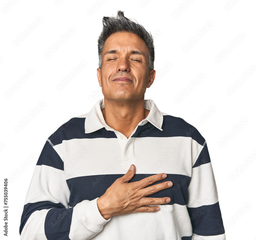 Middle-aged Latino man laughs out loudly keeping hand on chest. Middle-aged Latino man laughs out loudly keeping hand on chest.