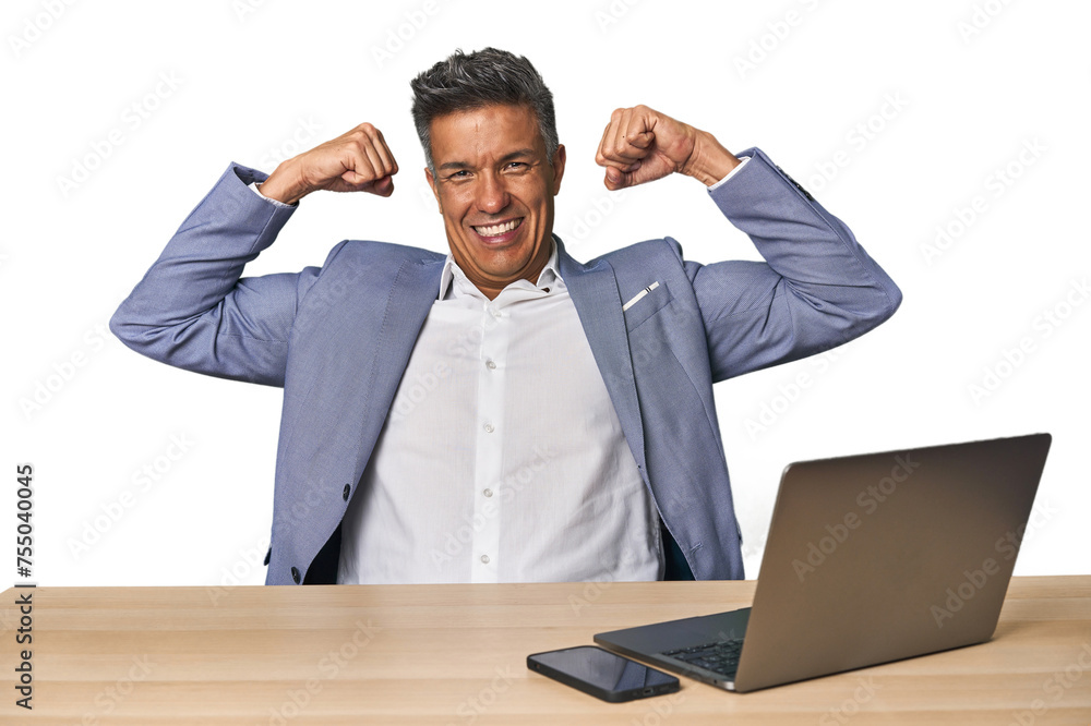 Elegant businessman at desk with laptop showing strength gesture with arms, symbol of feminine power Elegant businessman at desk with laptop showing strength gesture with arms, symbol of feminine power