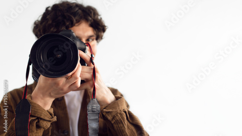 Close-up of male photographer with DSLR camera focusing intently photo