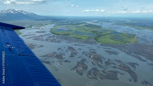 Beechcraft Bonanza airplane wingtip flies over Susitna River, Cook Inlet's Knik Arm in Alaska. Small aircraft are only way to see many areas of Alaska. Susitna flats, braided river and mud flats. photo