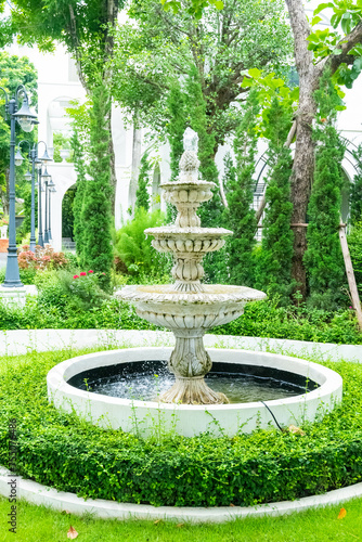 Luxury water fountain in the park,The three tiered fountain in english garden,Home garden in retro style.