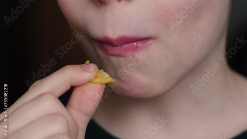 Wallpaper Mural portrait of a smiling happy Caucasian boy 10 years old eating potato chips. Light snack, boy and his favorite chips Torontodigital.ca