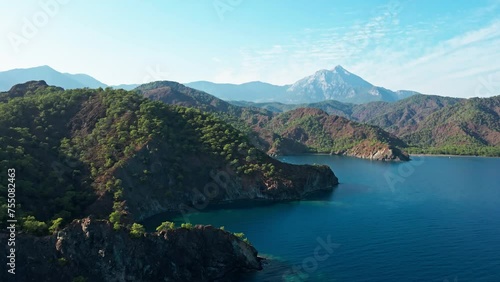 Aerial view on the blue sea with high cliffs and mountains along the coast photo