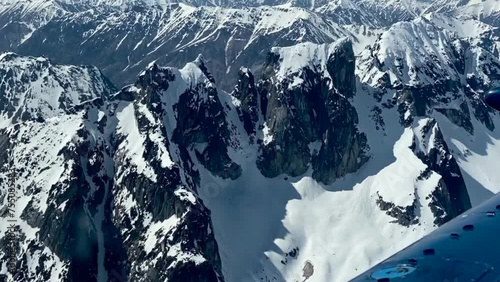 Beechcraft Bonanza airplane wingtip flies over Lake Clark Pass in Alaska. Mount Redoubt in the background. Small aircraft are only way to see many areas of Alaska. photo