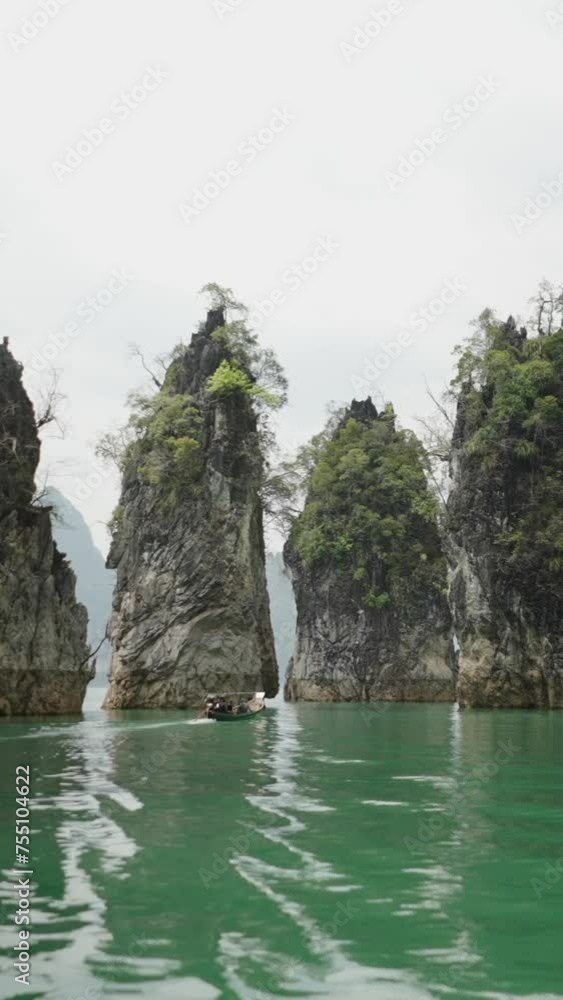 A boat in the distance sails on a lake between mountains A boat in the distance sails on a lake between mountains