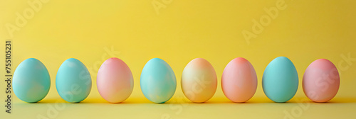 colorful pastel eggs in a row on yellow background